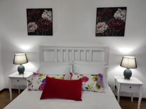 a bedroom with a white bed with two tables and two lamps at Casa Corredoura in Ponte de Lima