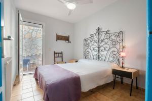 a bedroom with a bed and a table with a lamp at Casa Rosana by MarCalma in Miami Platja