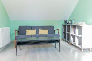 翁贊的住宿－Le Cissereau - Chambres et table d'hôtes，客厅配有带两个枕头的蓝色沙发