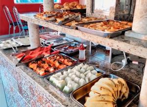 a buffet with many trays of food on a table at Pousada Clube Santa Cruz in Santa Cruz de Minas