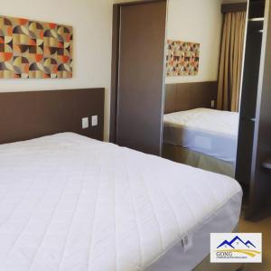 a bedroom with two beds and a mirror at Park Veredas Flat Service Rio Quente - GO Apto 416 in Rio Quente