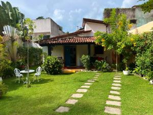 un giardino con sedie e tavolo e una casa di Casa Vila Tortuga a Arraial d'Ajuda