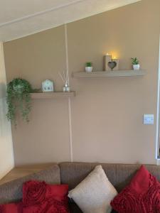 a living room with a couch with red pillows at DaisyChain 2 Getaways - The perfect place to Stay - Play - Getaway in East Mersea