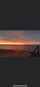 a view of the ocean at sunset from a pier at DaisyChain 2 Getaways - The perfect place to Stay - Play - Getaway in East Mersea