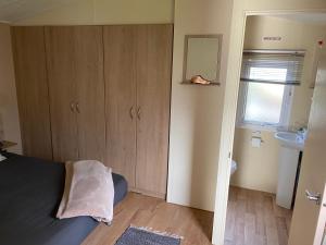 a small bedroom with a bed and a sink at DaisyChain 2 Getaways - The perfect place to Stay - Play - Getaway in East Mersea +34 photos