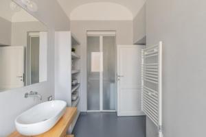 a white bathroom with a sink and a mirror at iFlat Saint Peter Bright Apartment in Rome