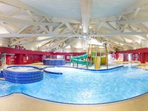 a large indoor swimming pool with two water slides at Belvilla by OYO Vent in Livigno