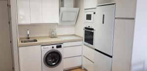 a kitchen with white cabinets and a washer and dryer at CHINASOLYMAR LUXURY - Con Parking in Almuñécar