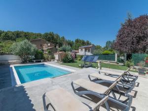 a swimming pool with two lounge chairs and a swimming pool at Superb house with pool near the Luberon in Oppède