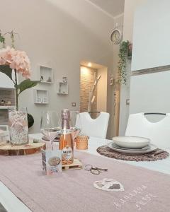 einen Tisch mit einem Tischtuch mit Gläsern und einer Flasche Wein in der Unterkunft CAMARDA SUITE in Bernalda