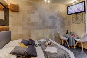 een slaapkamer met een bed en een tv aan de muur bij SOUS MON TOI Topdestination-Dijon - Sauna & jacuzzi - Classé 3 étoiles in Dijon