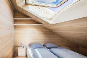 Bett in einem Zimmer mit Dachfenster in der Unterkunft Ferienhaus Bergfrieden Laterns auf 1.170 m in Laterns