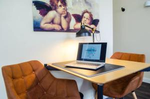 a laptop on a table with a lamp on it at HOMELY STAY Studio 3 in Munich