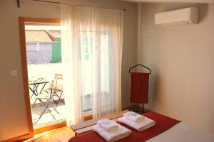 - une chambre avec 2 serviettes sur un lit en face d'une fenêtre dans l'établissement OportoHost Campanhã, à Porto