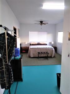 een slaapkamer met een bed en een blauwe vloer bij Ocean View Paradise! in Hawaiian Ocean View