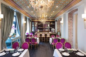 ein Restaurant mit lila Stühlen und Tischen und einer Bar in der Unterkunft Itza Hotel Boutique Internacional in Cuenca