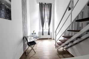 un pasillo con escaleras, una mesa y una ventana en Rio's Stylish Central Flats, en Budapest