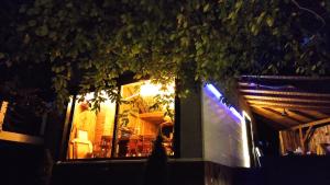 a tree in front of a restaurant at night at Forest Art Villa Zagreb in Sveta Nedjelja