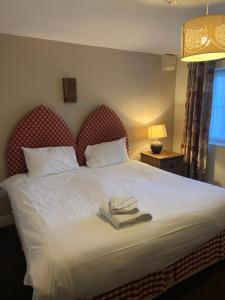 a bedroom with a bed with two towels on it at The Barrington Arms Hotel in Shrivenham