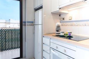 uma cozinha com armários brancos e um frigorífico branco em lux&Cool Paseo Marítimo em Almeria