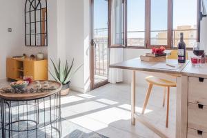 uma cozinha com mesa, cadeiras e janelas em lux&Cool Paseo Marítimo em Almeria