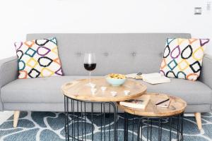 uma sala de estar com um sofá e uma mesa com um copo de vinho em lux&Cool Paseo Marítimo em Almeria