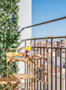 uma mesa com um prato de comida numa varanda em lux&Cool Paseo Marítimo em Almeria