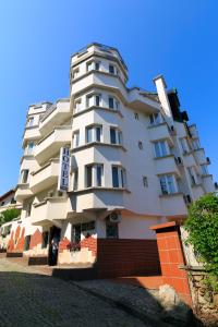 a tall white building with a sign on it at HOTEL THE WHITE HOUSE Plovdiv in Plovdiv