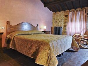 1 dormitorio con 1 cama grande y pared de piedra en Belvilla by OYO Mansion in Orvieto, en Orvieto