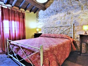 1 dormitorio con 1 cama en una pared de piedra en Belvilla by OYO Mansion in Orvieto, en Orvieto