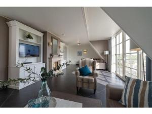 een woonkamer met een bank, een tv en een tafel bij Luxury holiday home in Colijnsplaat in Colijnsplaat