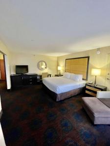 a hotel room with a bed and a flat screen tv at Brandywine Plaza Hotel in Claymont