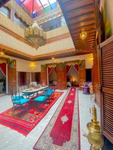 Cette chambre comprend une table, des chaises et un tapis rouge. dans l'établissement Riad el wazania, à Rabat