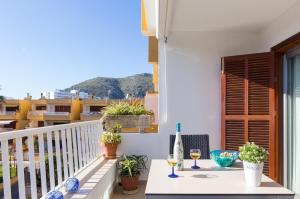 uma varanda com uma mesa e copos de vinho em Apartament Francesca Beach with Pool na Alcúdia