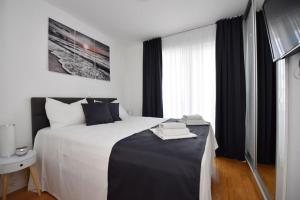 sypialnia z dużym białym łóżkiem i oknem w obiekcie Apartman Bora 1 w Novalji