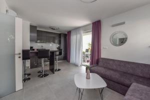 een woonkamer met een bank en een tafel bij Apartman Bora 1 in Novalja