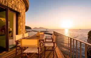 a balcony with a table and chairs overlooking the ocean at La Torre del Vervece in Massa Lubrense