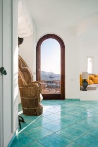 a living room with a turquoise tile floor and chairs at La Torre del Vervece in Massa Lubrense