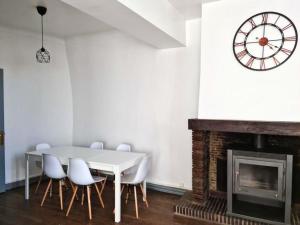 ein Esszimmer mit einem weißen Tisch und einer Uhr an der Wand in der Unterkunft Appartement de 3 chambres avec wifi a Beaugency in Beaugency