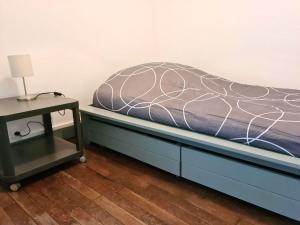 ein Bett mit einem blauen Bettrahmen neben einem Nachttisch in der Unterkunft Appartement de 3 chambres avec wifi a Beaugency in Beaugency