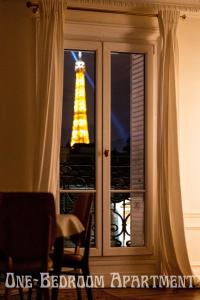 einen Blick auf den Eiffelturm durch ein Fenster in der Unterkunft Eiffel Tower view Residence in Paris