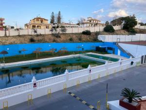 uma vista superior de uma piscina com água azul em Apartamento La Piedra em Matalascañas
