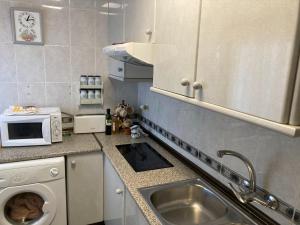 a small kitchen with a sink and a microwave at Apartamento La Piedra in Matalascañas
