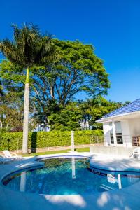 een zwembad voor een huis met een palmboom bij Hotel Palma Verde in Armenia