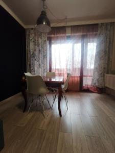 a dining room with a table and chairs and a window at Homey art apartment next to Drujba lake Metro stations and bul.Tsarigradsko Shose in Sofia