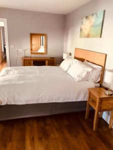 sypialnia z dużym białym łóżkiem i dwoma stołami w obiekcie Leanna's Lodge, Keshcarrigan w mieście Leitrim