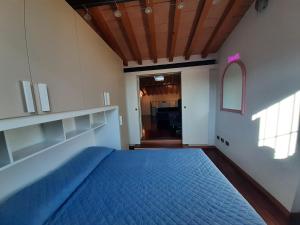 a bedroom with a blue bed in a room at Appartamento sui tetti di Parma in Parma