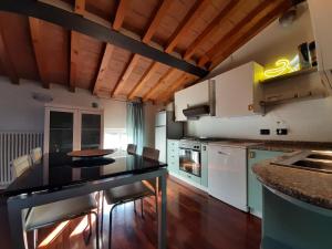 a kitchen with white cabinets and a black counter top at Appartamento sui tetti di Parma in Parma