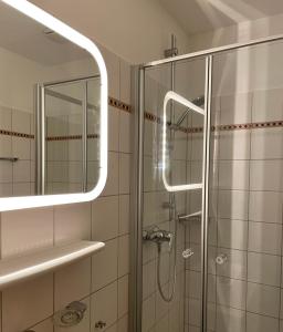 ein Bad mit einer Dusche und einem Spiegel in der Unterkunft Hotel Jägerhof in Coesfeld