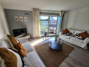 City Centre Snow Hill Apartment (Sleeps 6) في برمنغهام: غرفة معيشة مع أثاث أبيض ونافذة كبيرة
